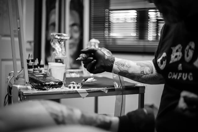 Tattoo artist preparing a machine at their station