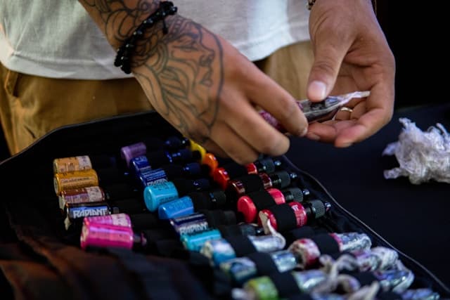 Artist picking ink bottles from a supply case