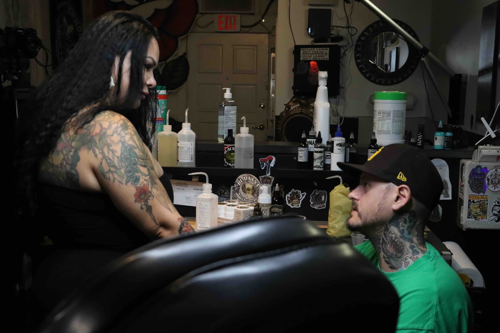 Tattoo artists talking at their station in a Tampa shop